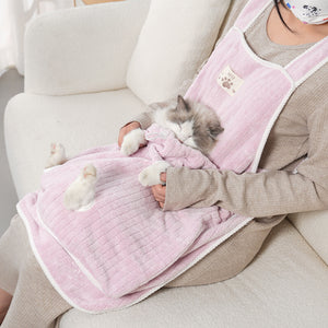 Pet owner wearing the PAWABY cat grooming apron at home.
